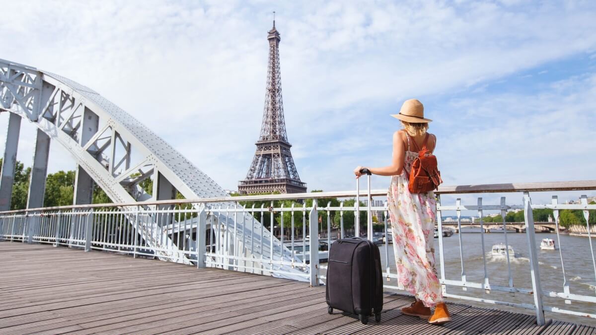Travel-to-Paris-Europe-tour-woman-with-suitcase-near-Eiffel-Tower-France.jpg